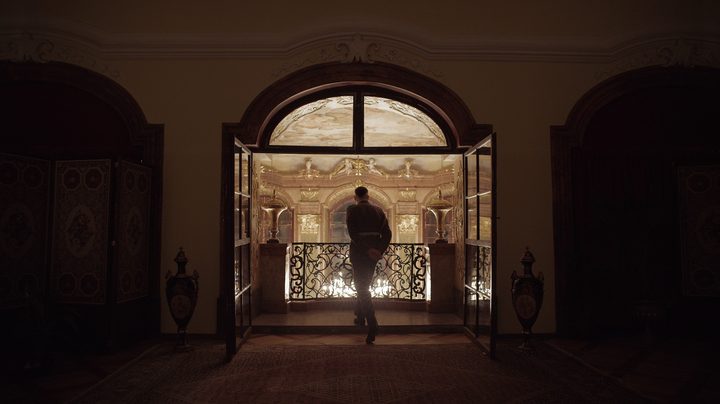A man stands on a balcony in The Zone of Interest.