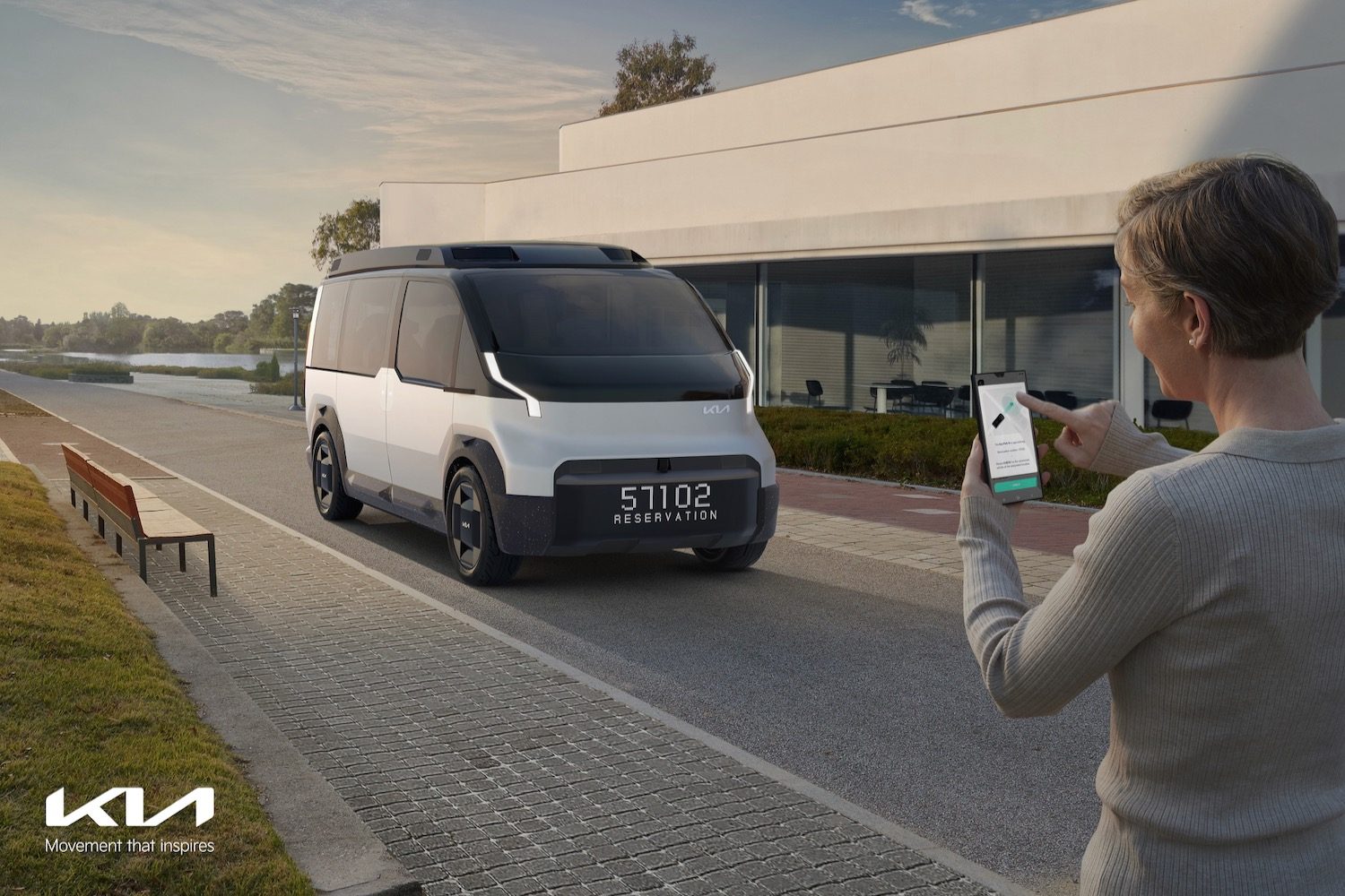A Kia Concept PV5 being hailed by a person via smartphone.