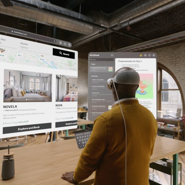 A man wearing the Vision Pro looking at virtual screens.