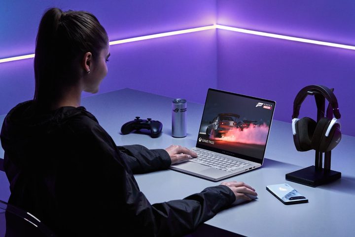 A person using the Asus ROG Zephyrus G14 laptop on a desk.