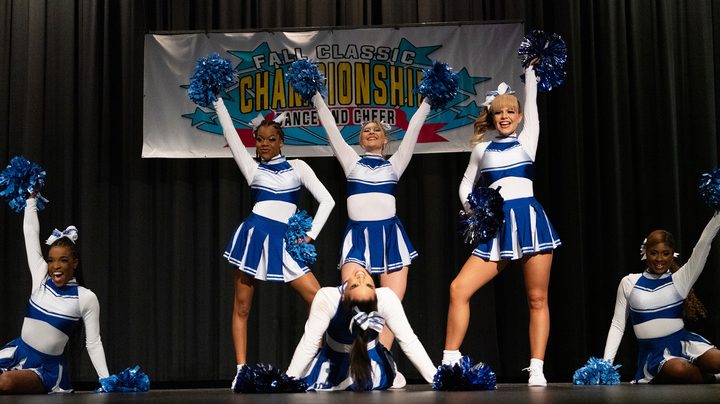A cheerleading group performing on stage in the gilm Blood Sweat and Cheer.