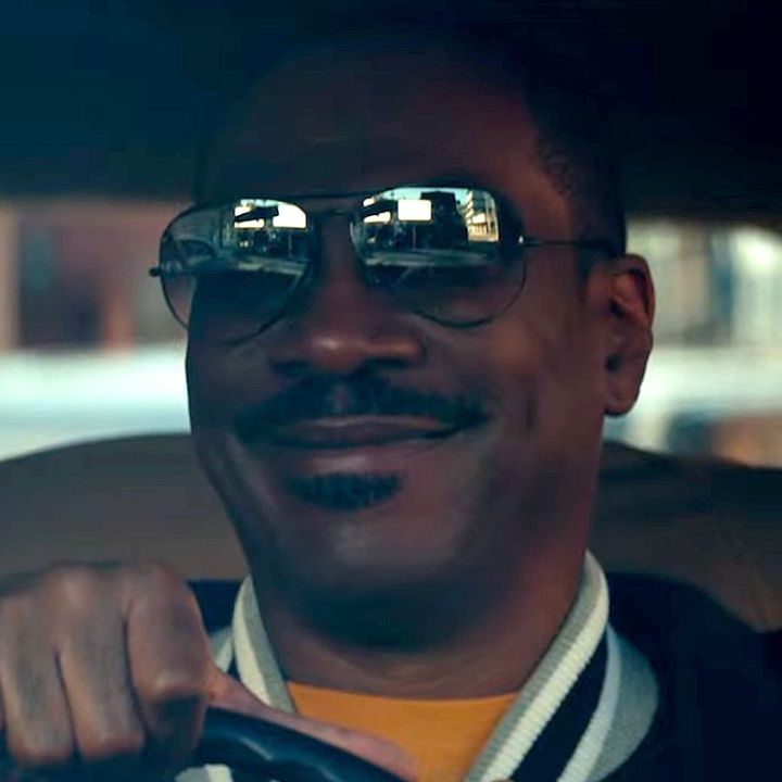 Eddie Murphy as Axel Foley smiling while driving a car in Netflix's "Beverly Hills Cop: Axel F."