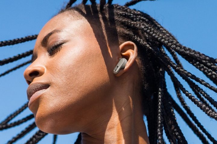 Woman wearing JBL Live Beam 3 in silver.