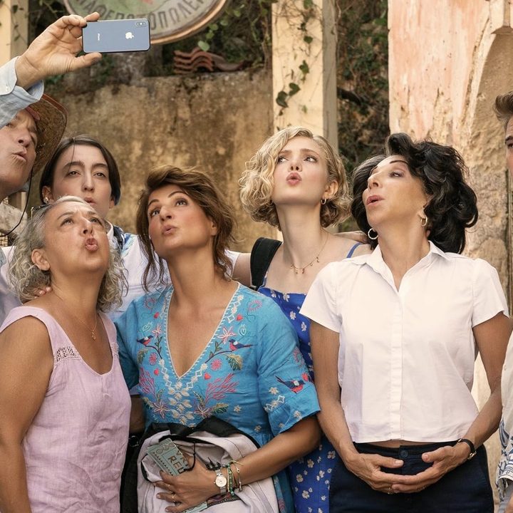 A family poses for a selfie and smiles.