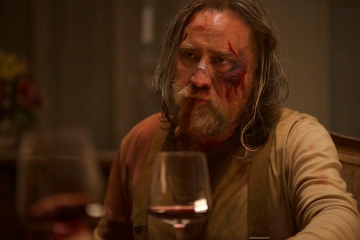 A man sits at a dinner table in Pig.