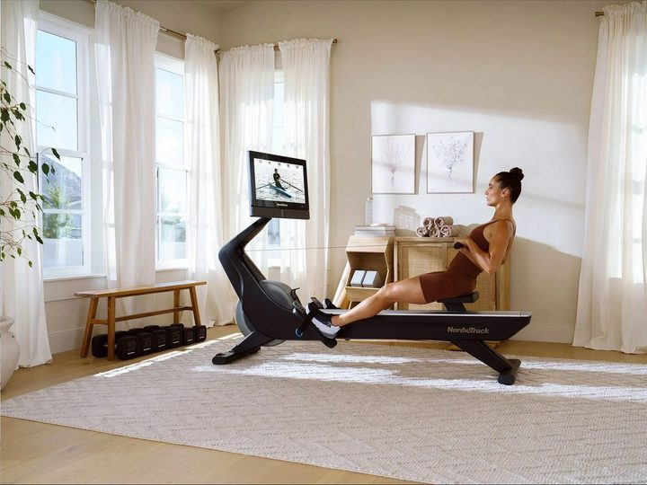 A woman doing a workout on the NordicTrack RW900 with iFit enabled.