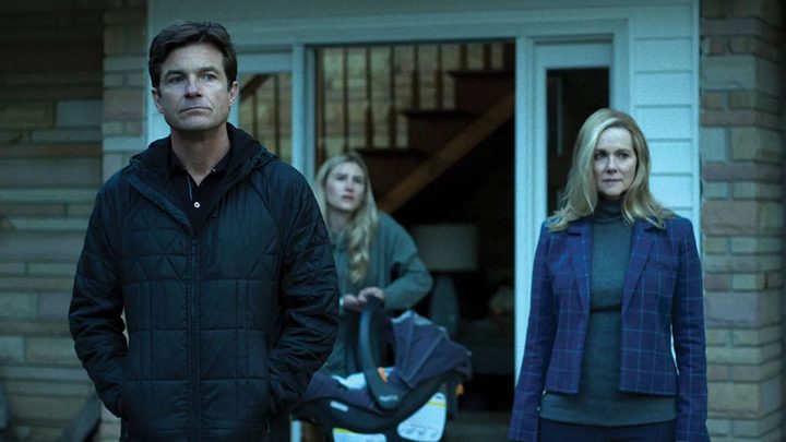 Jason Bateman and Laura Linney as Marty and Wendy Byrde outside of their home looking ahead in Ozark.