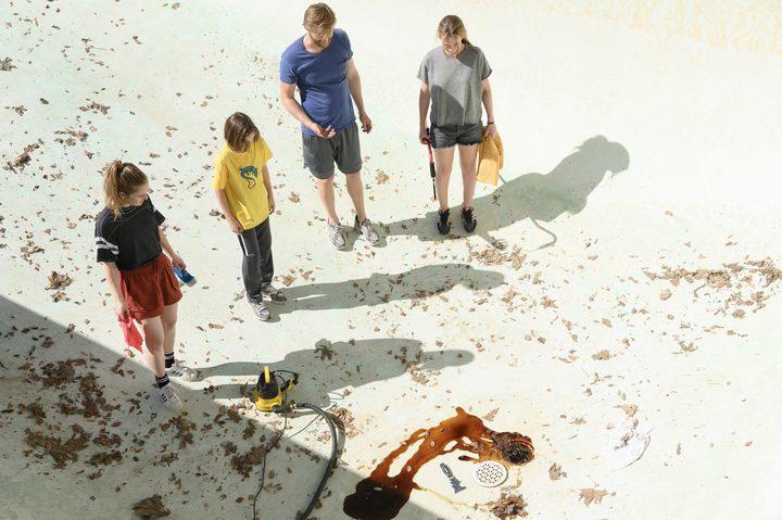 The Waller family stands in a drained pool in Night Swim.