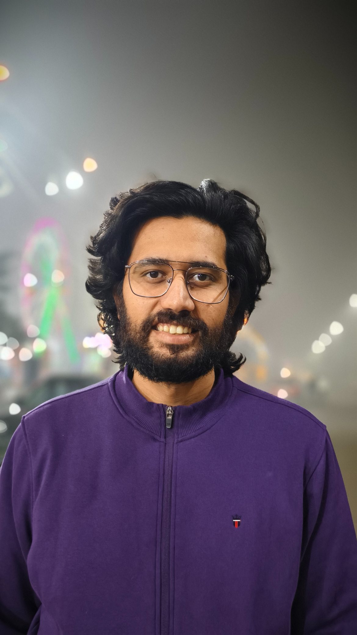 Portrait of a man wearing purple jacket shot on the Vivo X100's Zeiss camera.