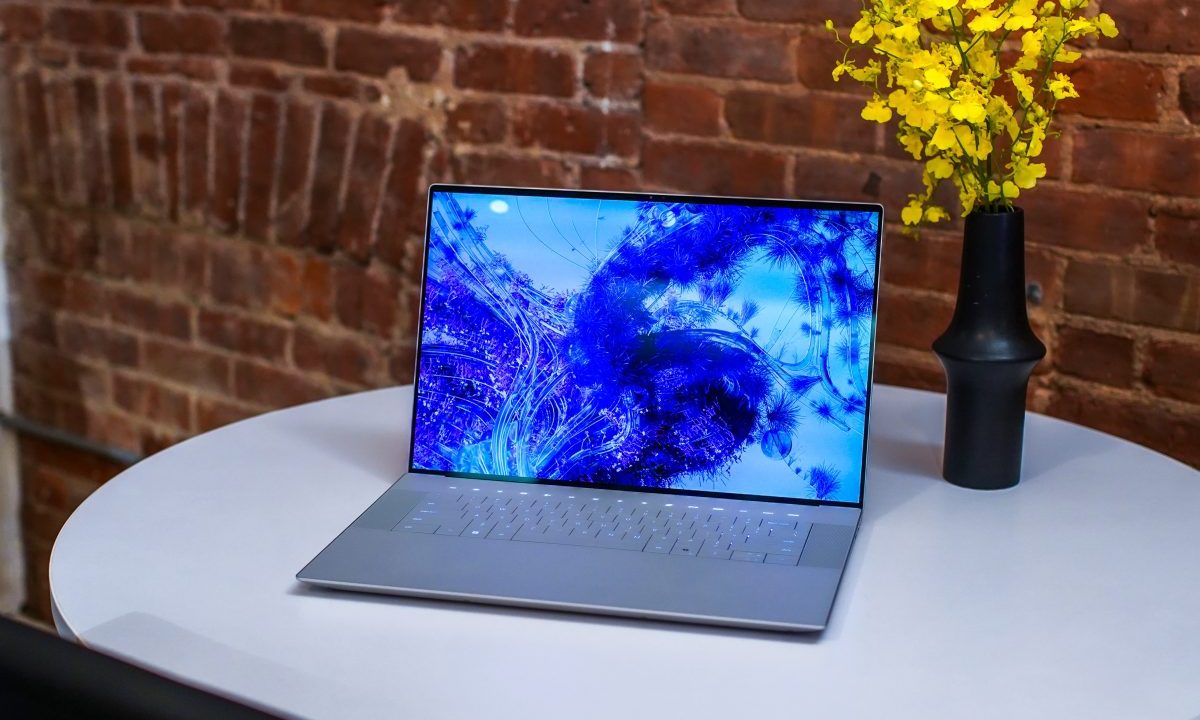 Dell XPS 16 sitting on desktop with flowers.