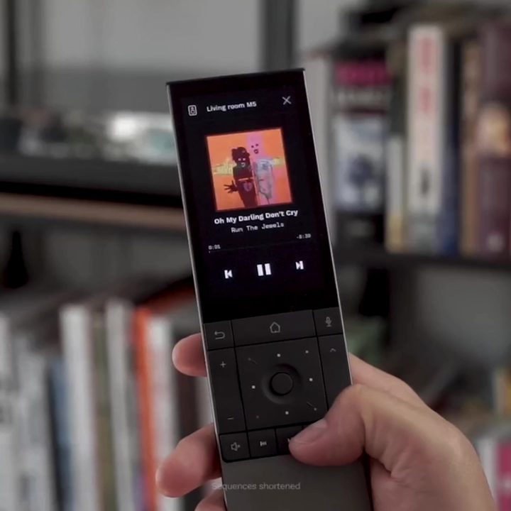 A Yio remote held in hand.