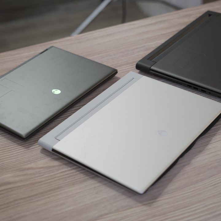 Three Alienware gaming laptops on a table.