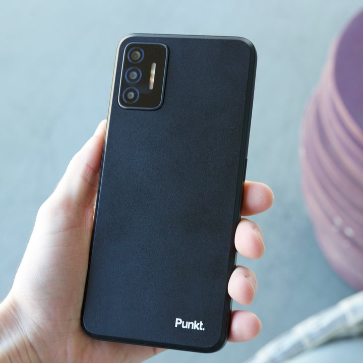Someone holding the Punkt MCO2 smartphone and showing the back of it.