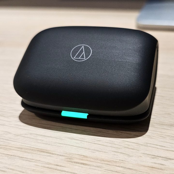 Audio-Technica ATH-TWX7 charging case closed with lit LED.