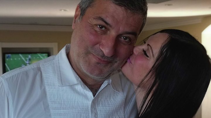 Benita Alexander kissing Paolo Macchiarini on the cheek as he looks at the camera in footage from Bad Surgen: Love Under the Knife.