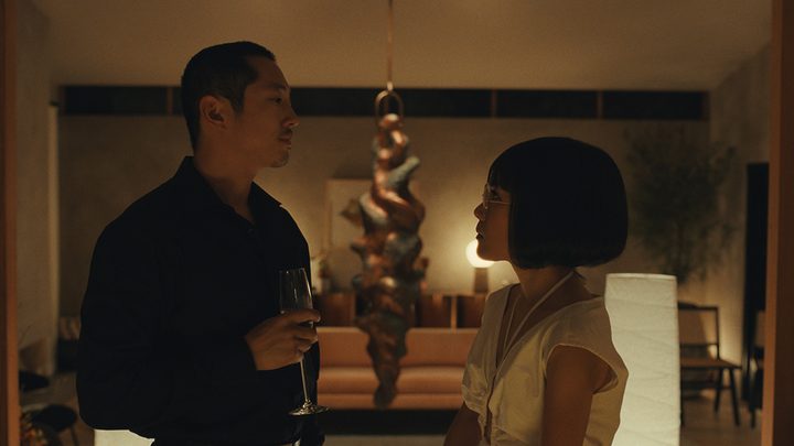 A man and woman in the dark look at one another angrily in a scene from Beef on Netflix.