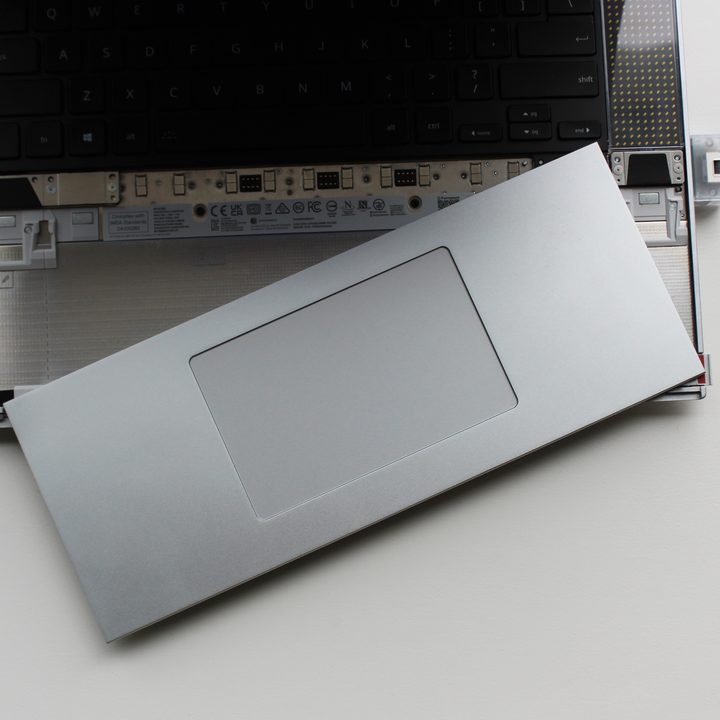 The touchpad and spacers removed off the Framework Laptop 16.