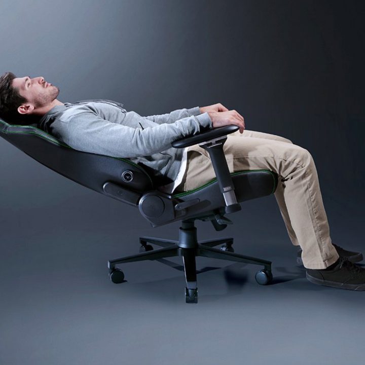 A model laying reclined on the Razer Izkur V2 gaming chair.
