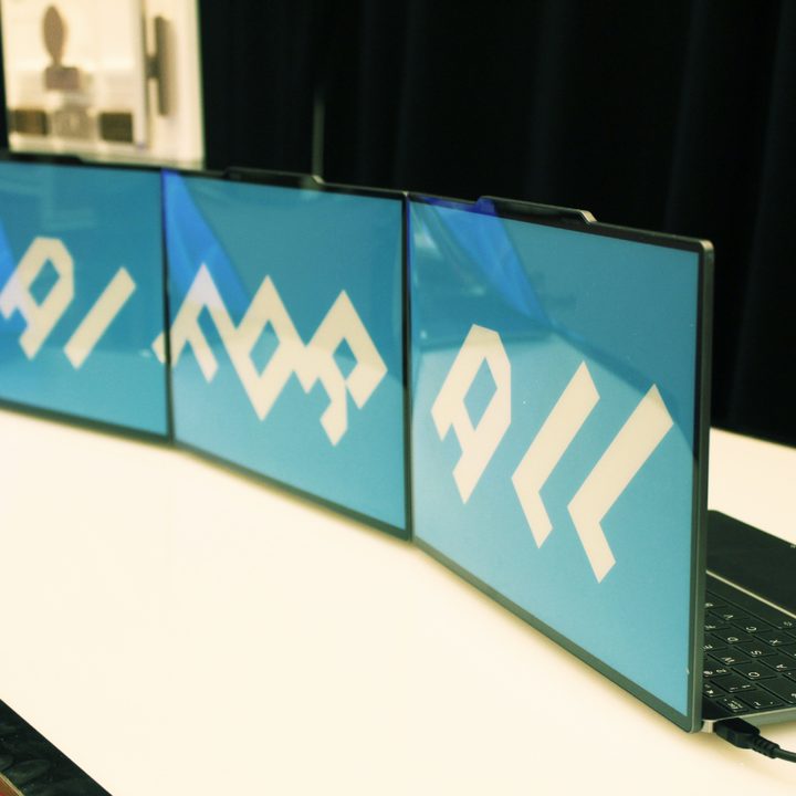 Three of the e-ink lid laptops on a table.