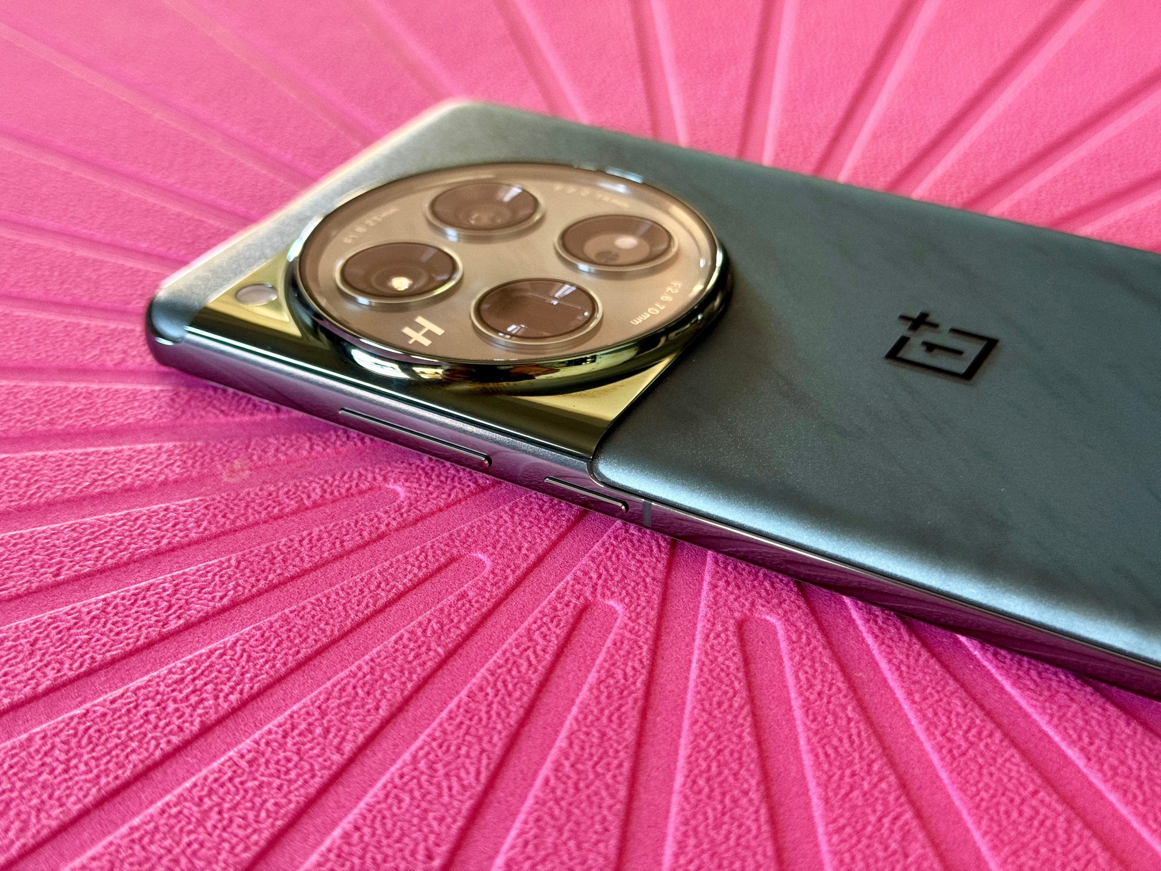 OnePlus 12 in Flowy Emerald showing volume and power buttons.