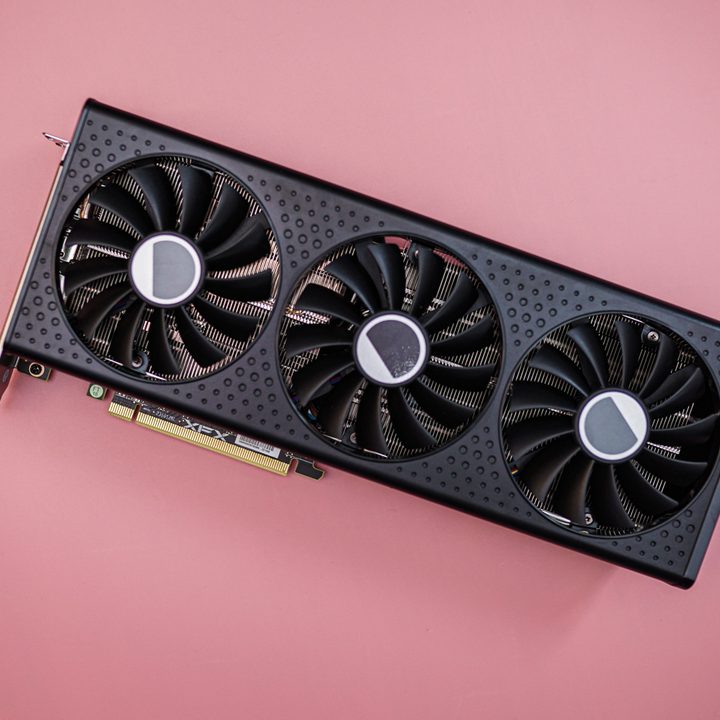 The RX 7600 XT graphics card on a pink background.