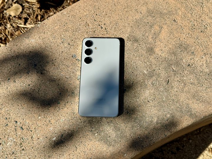 Samsung Galaxy S24 in Marble Gray laying on a concrete bench.