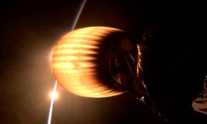 A SpaceX Falcon 9 engine burns against an orbital sunset.