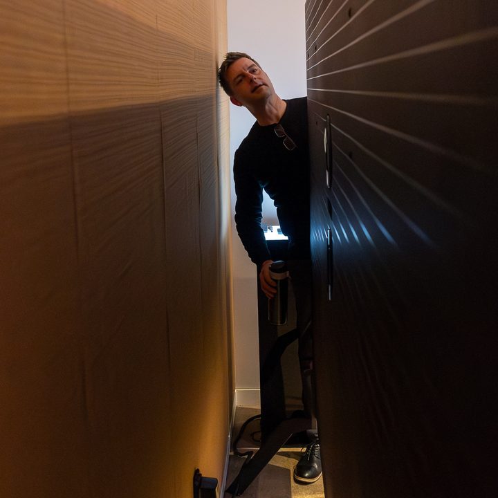 Caleb Denison peers behind the 115-inch TCL QM89 television.