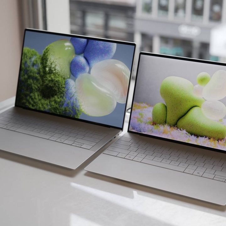 The XPS 14 and 16 in front of a window.