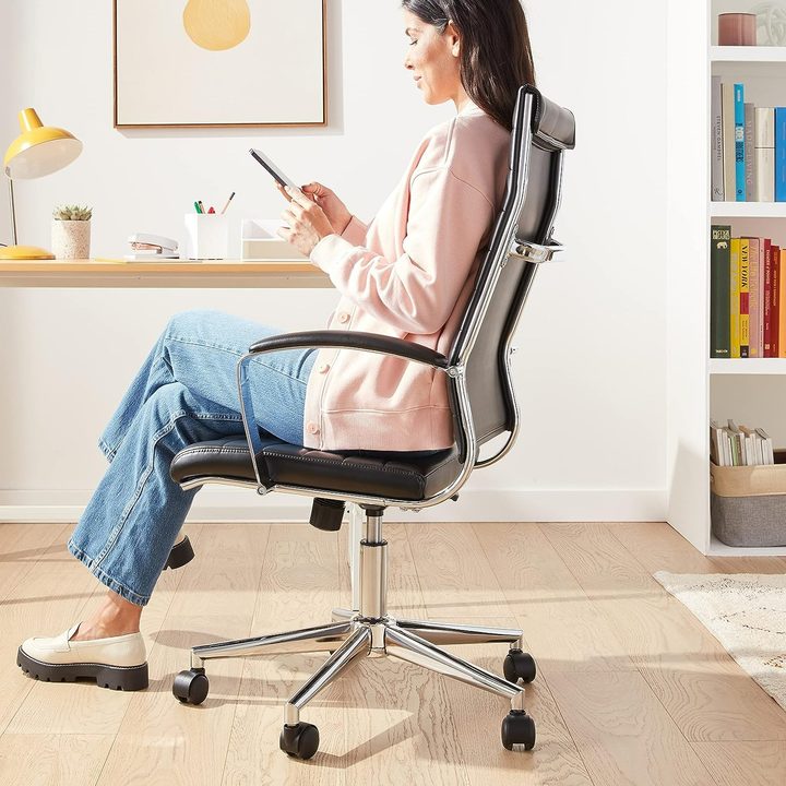 A person sitting in the Amazon Basics chair.