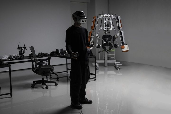 A Varjo XR-4 VR headset is worn by a person standing in front of robotic exoskeleton.