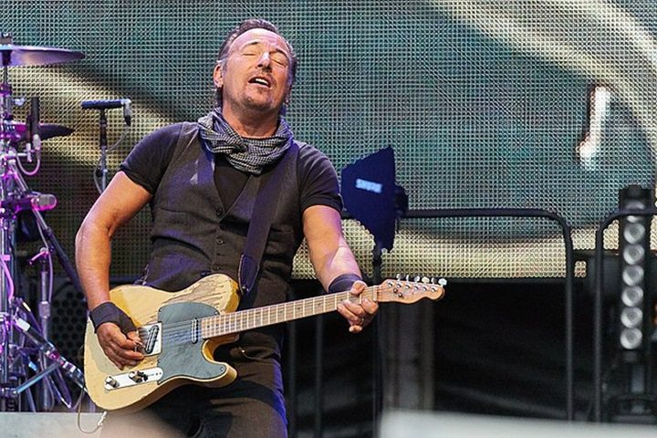 Bruce Springsteen holds his guitar at a concert.