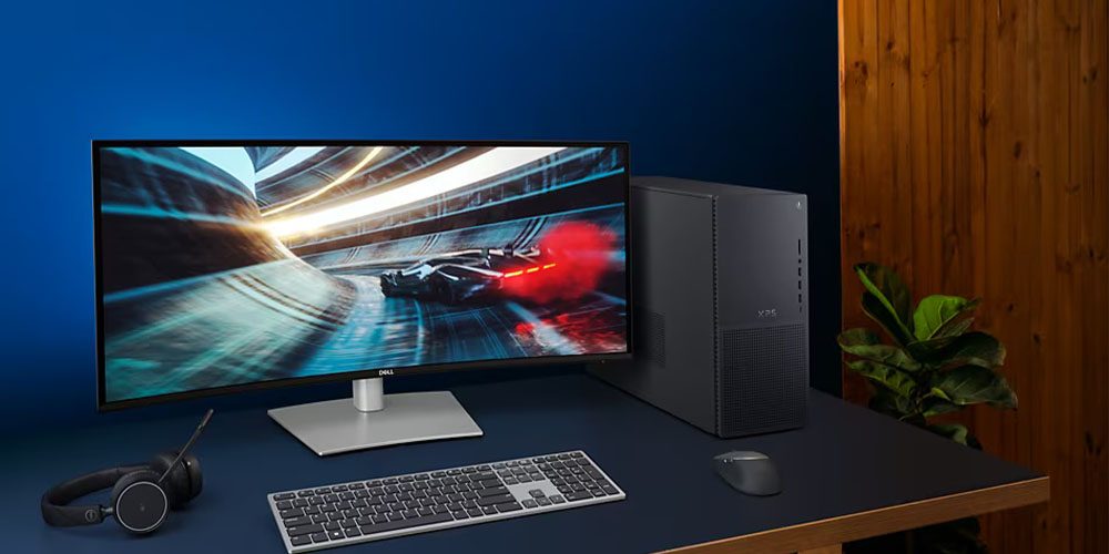 The Dell XPS Desktop on a desk next to a gaming monitor and keyboard.