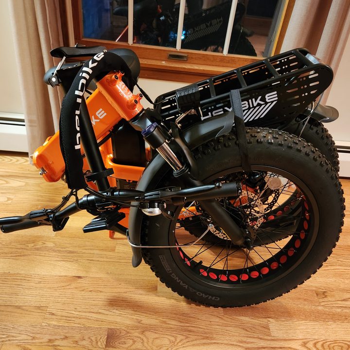 HeyBike Mars 2.0 folding e-bike in folded state with pedals, frame, and handlebar stem folded and Velcroed in place.