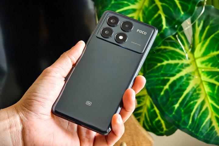 Person holding POCO X6 Pro in front of indoor plant.
