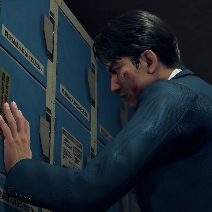 Ryo Aoki pressing his hand up to the blue coin lockers. his face is beaten and he is wearing a blue suit.