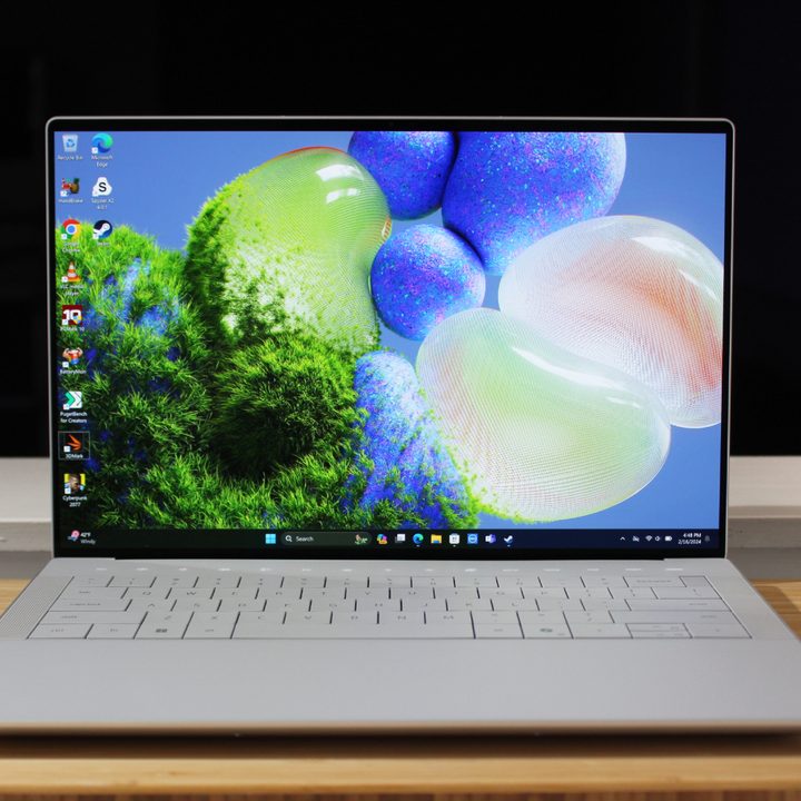The Dell XPS 14 open on a wooden table.