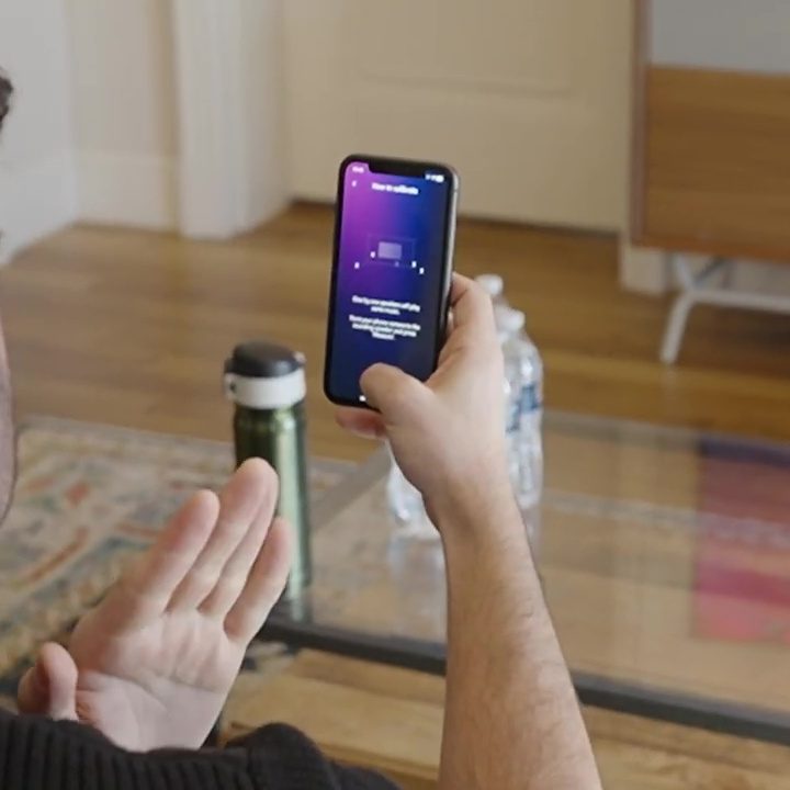 A man using an app to interact with Dolby Atmos FlexConnect.