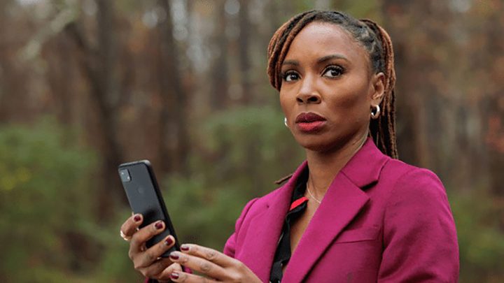 Gabi from Found holding her phone, looking scared.