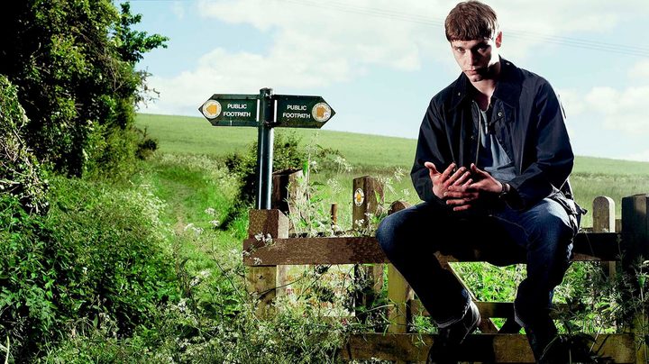A man sits on a post outside in Glue.