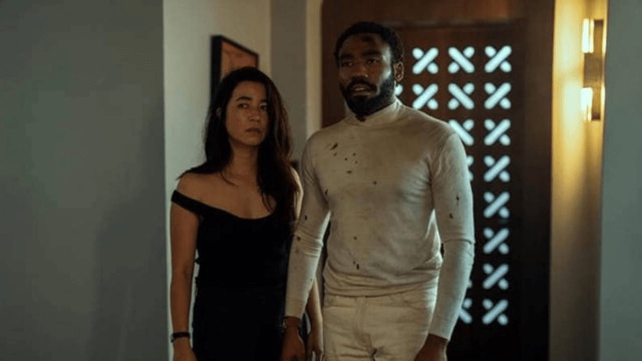 A man and woman stand by a doorway looking disheveled in a scene from Mr. & Mrs. Smith on Amazon Prime Video.