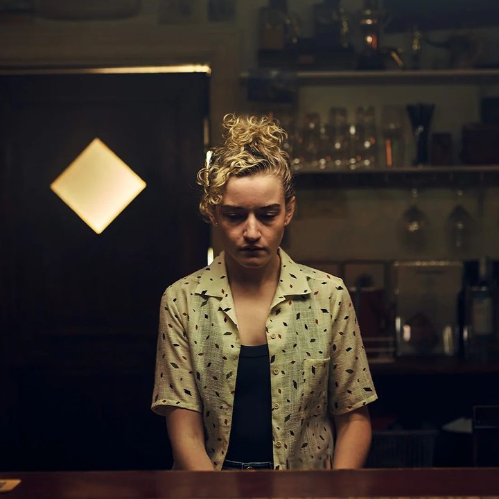 A woman looks down in The Royal Hotel.