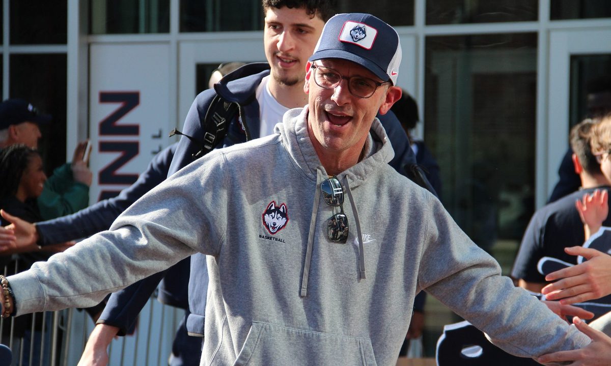 UConn coach Dan Hurley puts his hands out and poses.