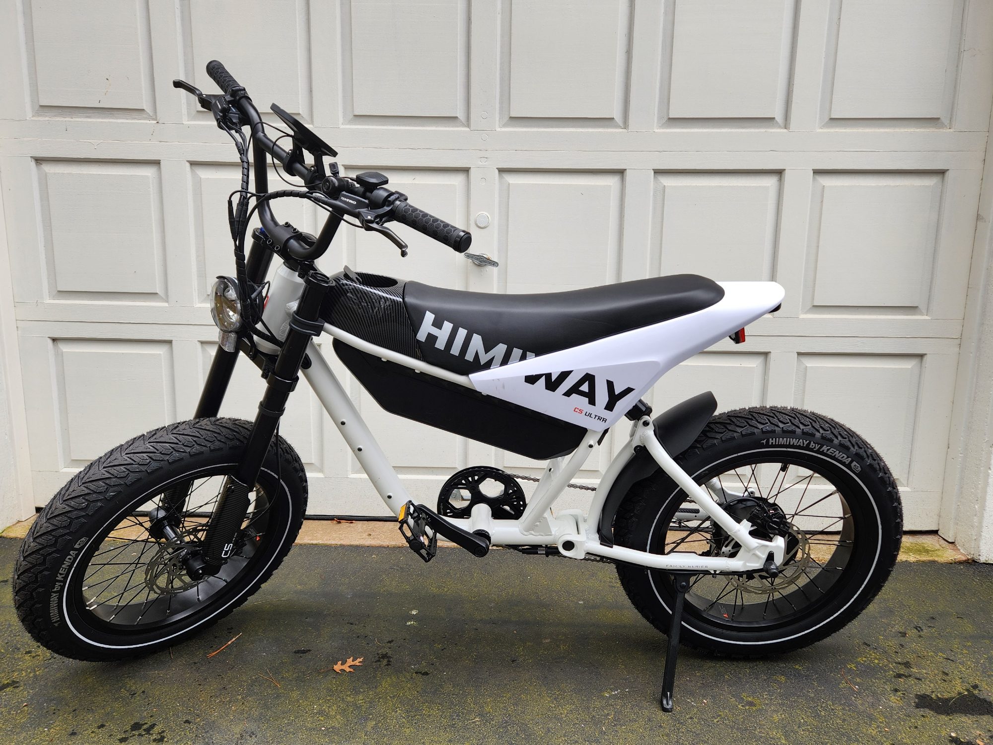 Himiway C5 e-bike left side of the bike parked in front of a garage door.