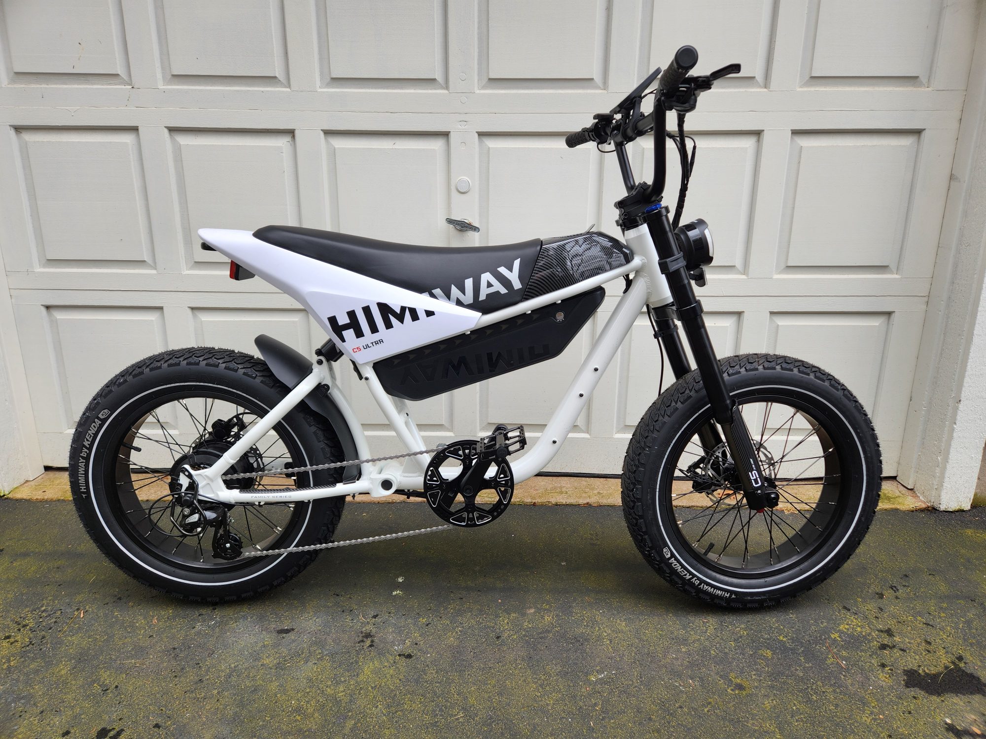 Himiway C5 e-bike right side of the bike parked in front of a garage door.
