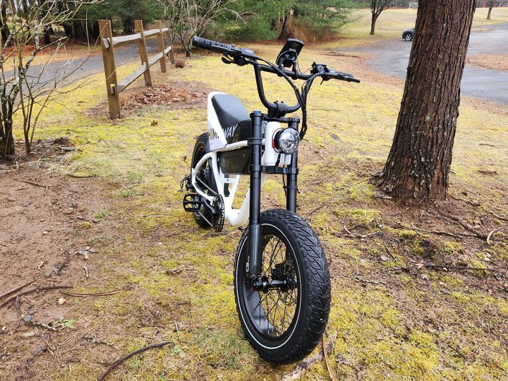 Himiway C5 e-bike right side three-quarter view of the bike parked on arise next to a parking lot.