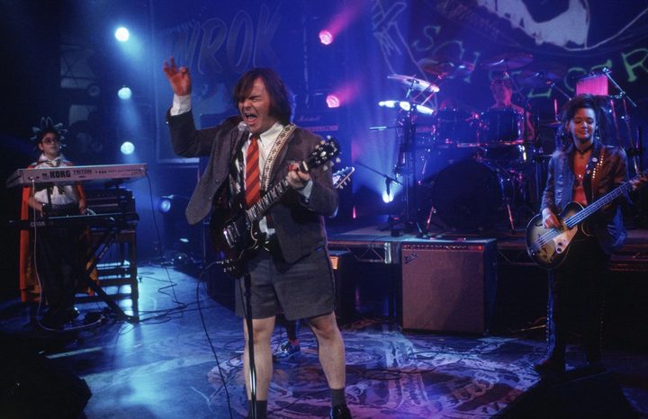 Jack Black and kids stand onstage and play instruments.