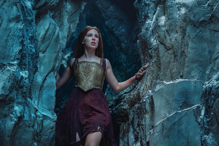 Millie Bobby Brown looks out of a mountain cave in Damsel.