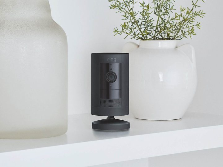 The Ring Stick Up Cam Battery among decorations on a shelf.