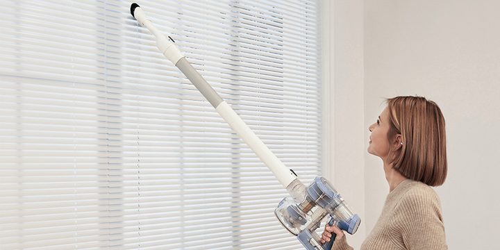 A woman using the Tineco cordless vacuum.